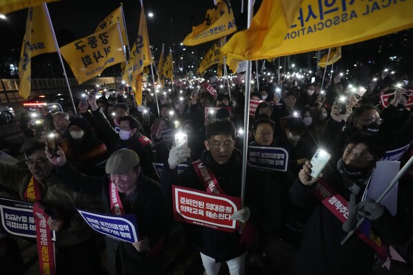 Doctors stage a rally against the government's medical policy near the presidential office in Seoul, South Korea, Thursday, Feb. 15, 2024. Hundreds of South Korean doctors rallied in the capital, Seoul, and other cities on Thursday in protest of a government plan to boost the number of medical students in the country. (AP Photo/Ahn Young-joon)