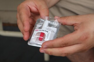 FILE - A member of the Solutions Oriented Addiction Response organization holds a dose of the opioid overdose reversal drug Narcan at the Unitarian Universalist Congregation of Charleston in Charleston, W.Va., Tuesday Sept. 6, 2022. Nearly 108,000 Americans died of drug overdoses in 2022, according to final federal figures released Thursday, March 21, 2024. (AP Photo/Leah Willingham, File)