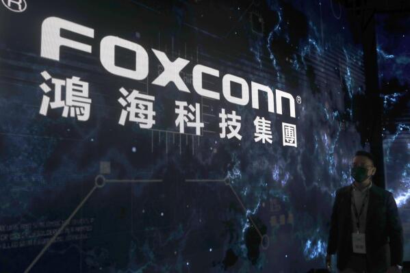 A man walks past the Foxconn logo during the 2022 Hon Hai Tech Day (HHTD 22) at the Nangang Exhibition Center in Taipei, Taiwan, Tuesday, Oct. 18, 2022. (AP Photo/Chiang Ying-ying)
