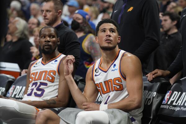 Phoenix Suns guard Devin Booker, front, and forward Kevin Durant check the clock during a time out late in the second half of Game 2 of an NBA second-round playoff series against the Denver Nuggets Monday, May 1, 2023, in Denver. (AP Photo/David Zalubowski)