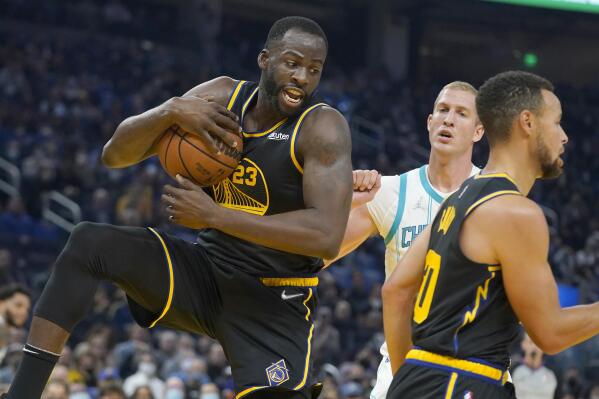 Golden State Warriors forward Draymond Green, left, grabs a rebound in front of Charlotte Hornets center Mason Plumlee, rear, during the first half of an NBA basketball game in San Francisco, Wednesday, Nov. 3, 2021. (AP Photo/Jeff Chiu)