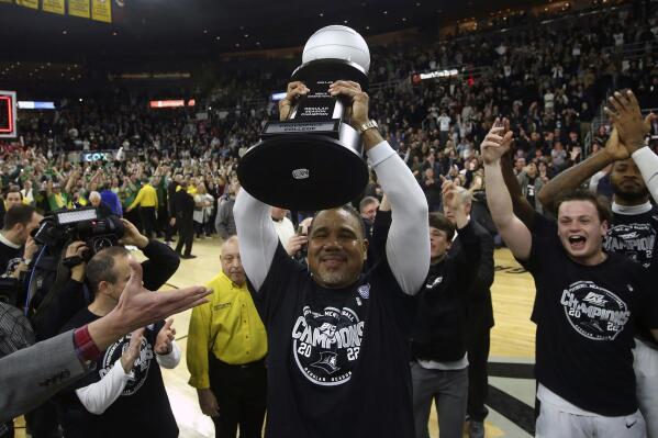 Providence head coach Ed Cooley raises the trophy after winning the Big East regular season title following an NCAA college basketball game against Creighton, Saturday, Feb. 26, 2022, in Providence, R.I. (AP Photo/Stew Milne)