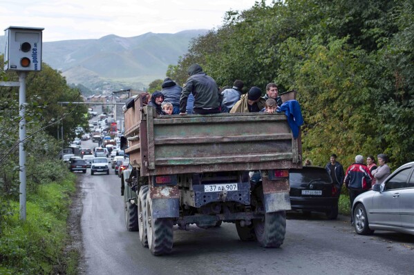 Ethnic Armenians from Nagorno-Karabakh sit in a truck on their way to Goris in Syunik region, Armenia, on Tuesday, Sept. 26, 2023. Thousands of Armenians have streamed out of Nagorno-Karabakh after the Azerbaijani military reclaimed full control of the breakaway region last week. (AP Photo/Gaiane Yenokian)