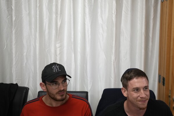 Tomer Bassis, left, and Eyal Sirota recount their experiences from the Oct. 7 attack by Hamas militants on a rave part in the southern Israel, at Cyprus' Jewish Community Center in the southern coastal town of Larnaca, Cyprus, on Thursday, Nov. 30, 2023. Bassis and Sirota was among a group of 70 people who attended a retreat in Cyprus to help them cope with the psychological trauma they suffered from that attack. (AP Photo/Petros Karadjias)