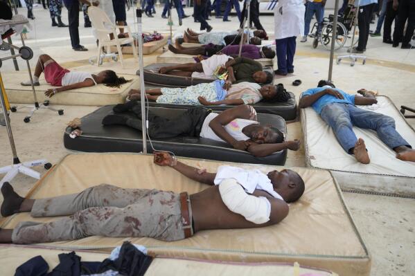 Victims of a train crash receive treatment outside the emergency unit of the Lagos general hospital in Ikeja Lagos, Nigeria, Thursday March 9, 2023. Three people were killed and more than 80 injured after a passenger bus was crushed by a moving train in Nigeria's commercial hub of Lagos, the emergency response agency said on Thursday. (AP Photo/Sunday Alamba)