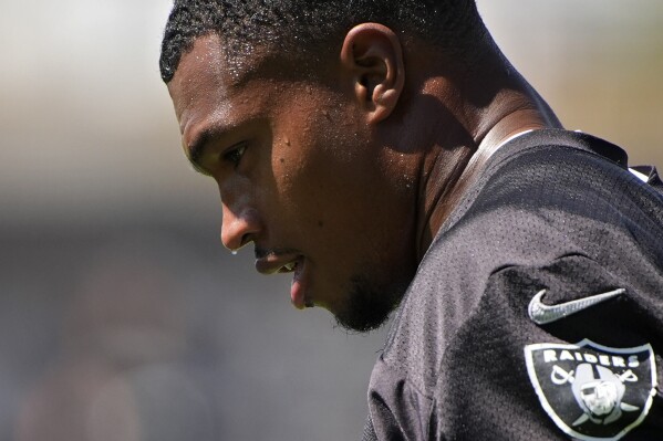 FILE - Las Vegas Raiders defensive end Tyree Wilson (9) sweats as he warms up during NFL football practice, June 4, 2024, in Henderson, Nev. Month after month, global temperatures are setting new records. (AP Photo/John Locher, File)