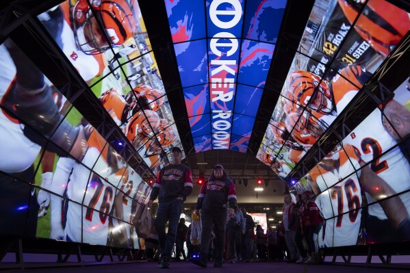 Fans walk through a tunnel of digital screens during NFL Experience ahead of Super Bowl 58, Saturday, Feb. 10, 2024, in Las Vegas. The Kansas City Chiefs will play the NFL football game against the San Francisco 49ers Sunday. (AP Photo/Gregory Bull)