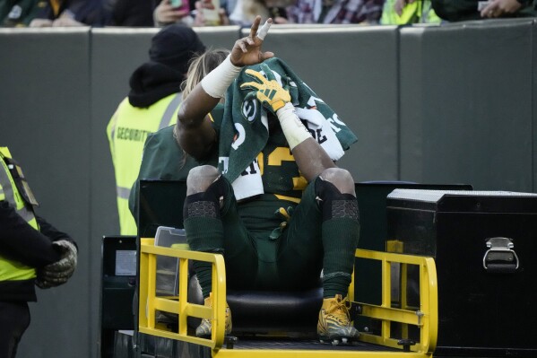 Green Bay Packers running back Aaron Jones is carted off the field during the first half of an NFL football game against the Los Angeles Chargers, Sunday, Nov. 19, 2023, in Green Bay, Wis. (AP Photo/Morry Gash)