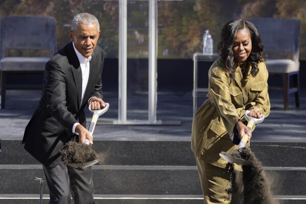 Former President Barack Obama, left, and former first lady Michelle Obama toss shovels of dirt during a groundbreaking ceremony for the Obama Presidential Center Tuesday, Sept. 28, 2021, in Chicago. (AP Photo/Charles Rex Arbogast)