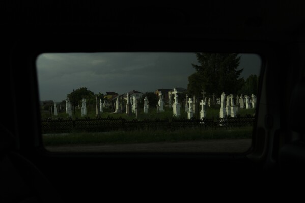 A cemetery is lit by the evening sunlight near Lviv, Ukraine, Sunday, July 2, 2023. (AP Photo/Jae C. Hong)