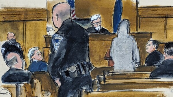 Former President Donald Trump, second from left, watches juror number d2 speak at the podium to Judge Juan Merchan in Manhattan criminal court regarding her desire to be excused from the jury after 