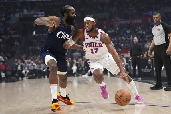 Philadelphia 76ers guard Buddy Hield (17) drives past Los Angeles Clippers guard James Harden during the first half of an NBA basketball game, Sunday, March 24, 2024, in Los Angeles. (AP Photo/Jae C. Hong)