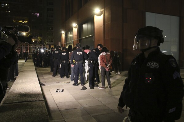 Policiais do Departamento de Polícia da cidade de Nova York prendem manifestantes pró-palestinos do lado de fora de um acampamento liderado por estudantes na Universidade de Nova York, segunda-feira, 22 de abril de 2024.  Protestos e acampamentos foram montados para exigir o desinvestimento da universidade dos fabricantes de armas e do governo israelense.  O NYPD disse na segunda-feira que 133 manifestantes foram presos e todos foram libertados com intimação para comparecer ao tribunal sob acusações de conduta desordeira.  (Foto AP/Nareen Naseer)