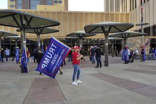 Supporters of Donald Trump gather on Friday, Nov. 20, 2020 in Phoenix, outside where the Maricopa County Board of Supervisors are meeting about certifying election votes. The elected leaders of Arizona's most populous county were expected to certify election results Friday that showed Democrat Joe Biden won the most votes. (AP Photo/Terry Tang)