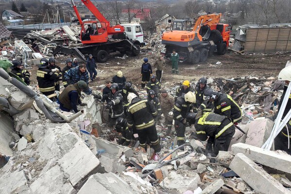 This photo released by Belgorod region governor Vyacheslav Gladkov's telegram channel on Monday, March 18, 2024, shows emergency ministry employees working at the destroyed building after shelling from the Ukrainian side, in Nikolskoye village, Belgorod region, Russia. Belgorod region governor Vyacheslav Gladkov says four people were killed in the shelling, not far from the border with Ukraine. (Belgorod Region Governor Vyacheslav Gladkov telegram channel via AP)