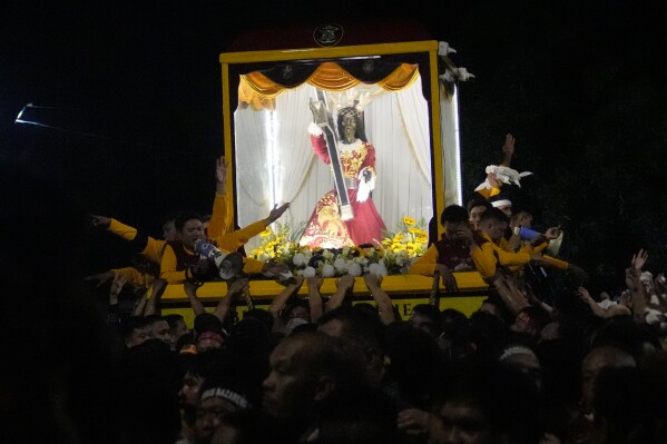 Devotees pull the statue of the Black Nazarene during its annual procession which was resumed after a three-year suspension due to the coronavirus pandemic on Tuesday, Jan. 9, 2024 in Manila, Philippines. A mammoth crowd of mostly barefoot Catholic devotees joined a chaotic procession through downtown Manila Tuesday to venerate a centuries-old black statue of Jesus Christ with many praying for peace in the Middle East where Filipino relatives work. (AP Photo/Aaron Favila)