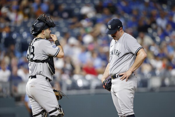 New York Yankees pitcher Carlos Rodon, right, waits as catcher Austin Wells, left, walks to the mound before Rodon was removed during the first inning of the team's baseball game against the Kansas City Royals in Kansas City, Mo., Friday, Sept. 29, 2023. (AP Photo/Colin E. Braley)
