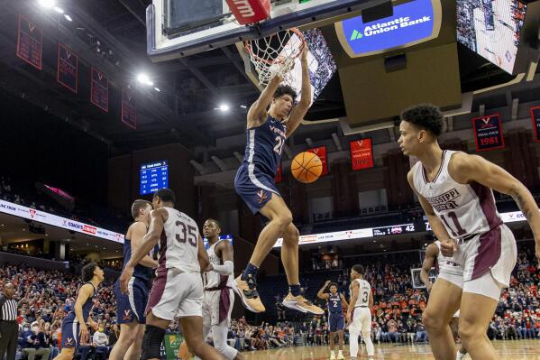 Virginia forward Kadin Shedrick (21) hangs from the basket after a dunk during the second half against Mississippi State in an NCAA college basketball game in the first round of the NIT, Wednesday, March 16, 2022, in Charlottesville, Va. (Erin Edgerton/The Daily Progress via AP)