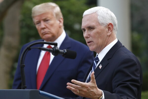 FILE - President Donald Trump listens as Vice President Mike Pence speaks during a coronavirus task force briefing in the Rose Garden of the White House, Sunday, March 29, 2020, in Washington. (AP Photo/Patrick Semansky, File)