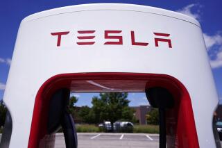 FILE - A Tesla Supercharger is seen at Willow Festival shopping plaza parking lot, Aug. 10, 2022, in Northbrook, Ill. On Monday, May 15, 2023, Delaware’s Supreme Court overturned a judge’s ruling upholding a decision by state officials to prohibit electric vehicle maker Tesla from selling its cars directly to customers. (AP Photo/Nam Y. Huh, File)
