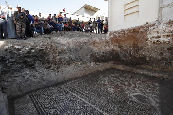 People look at a large mosaic that dates back to Roman era in the town of Rastan, Syria, Wednesday, Oct. 12, 2022. Syrian officials said it is the most important archaeological discovery since the conflict began 11 years ago. (AP Photo/Omar Sanadiki)