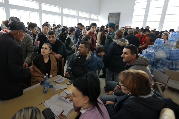 Ethnic Armenians who fled Nagorno-Karabakh line up to receive humanitarian aid at a temporary camp in Goris, in Armenia's Syunik region, Tuesday, Sept. 26, 2023. (AP Photo/Vasily Krestyaninov)