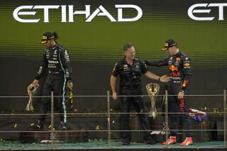 Red Bull team chief Christian Horner, center, celebrates with his driver Max Verstappen of the Netherlands after winning the Formula One Abu Dhabi Grand Prix in Abu Dhabi, United Arab Emirates, Sunday, Dec. 12, 2021. Max Verstappen ripped a record eighth title away from Lewis Hamilton, left, with a pass on the final lap of the Abu Dhabi GP to close one of the most thrilling Formula One seasons in years as the first Dutch world champion. (AP Photo/Hassan Ammar)