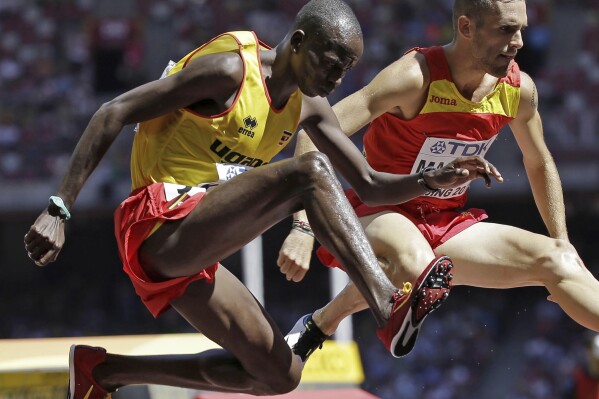 FILE - Uganda's Benjamin Kiplagat, front, competes in round one of the men's 3000m steeplechase during the World Athletic Championships at the Bird's Nest stadium in Beijing, Saturday, Aug. 22, 2015. Police in Kenya say they are investigating the slaying of three-time Ugandan Olympian Benjamin Kiplagat. A local police official says Kiplagat's body was found with stab wounds inside his brother’s car on Sunday morning. (AP Photo/David J. Phillip), File)