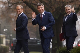 FILE - Polish Prime Minister Donald Tusk, left, Jan Grabiec, chief of staff, center, and newly appointed Minister of Digital Affairs Krzysztof Gawkowski, arrive at the Prime Minister's office in Warsaw, Poland, on Dec. 13, 2023. A fake news report on Poland's national news agency saying that Tusk was mobilizing 200,000 men starting on July 1 was probably the work of Russia-sponsored hackers and was designed to interfere with the upcoming European Parliament election, authorities said. “Everything indicates that we are dealing with a cyberattack directed from the Russian side," said Krzysztof Gawkowski." (AP Photo/Michal Dyjuk, File)