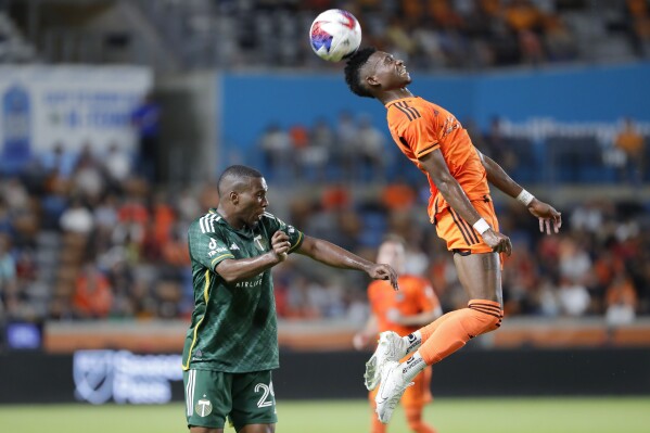 Houston Dynamo forward Nelson Quinones, right, heads the ball over Portland Timbers defender Juan David Mosquera, left, during the second half of an MLS soccer match Sunday, Aug. 20, 2023, in Houston. (AP Photo/Michael Wyke)