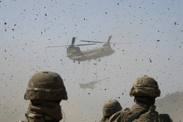 A U.S Army CH-47 Chinook helicopter transports a M777 howitzer during a joint military drill between South Korea and the United States at Rodriguez Live Fire Complex in Pocheon, South Korea, Sunday, March 19, 2023. (AP Photo/Ahn Young-joon)