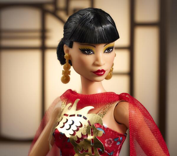 This image released by Mattel shows a Barbie doll in the image of Asian American Hollywood trailblazer Anna May Wong, part of their Inspiring Women Series. The doll is dressed in a frock inspired by Wong's appearance in the 1934 movie “Limehouse Blues,” a red gown with a shiny golden dragon design and cape. (Mattel via AP)