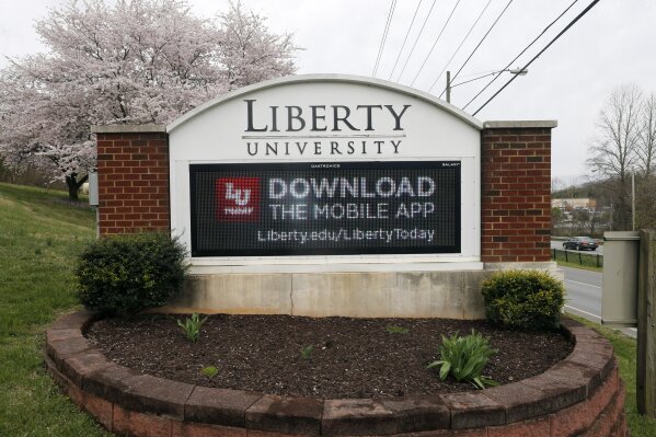 FILE - In this March 24, 2020 file photo, a sign marks the entrance to Liberty University in Lynchburg, Va.  Liberty University has filed a civil lawsuit against its former leader, Jerry Falwell Jr., seeking millions in damages after the two parted ways acrimoniously last year. The Associated Press obtained the complaint, which was filed Thursday, April 15, 2021 in Lynchburg Circuit Court. (AP Photo/Steve Helber, File)