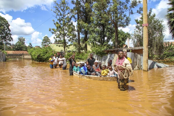 FILE - A family uses a boat after fleeing floodwaters that wreaked havoc in the Githurai area of Nairobi, Kenya, April 24, 2024. Extreme weather events have hit parts of Africa relentlessly in the last three years, with tropical storms, floods and drought causing crises of hunger and displacement. They leave another deadly threat behind them: some of the continent's worst outbreaks of cholera. In southern and East Africa, more than 6,000 people have died and nearly 350,000 cases have been reported since a series of cholera outbreaks began in late 2021. (AP Photo/Patrick Ngugi, File)