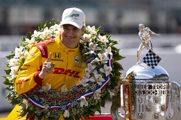 Indianapolis 500 champion Alex Palou, of Spain, poses with the Borg-Warner Trophy during the traditional winners photo session at Indianapolis Motor Speedway in Indianapolis, Monday, May 26, 2025. (AP Photo/Michael Conroy)