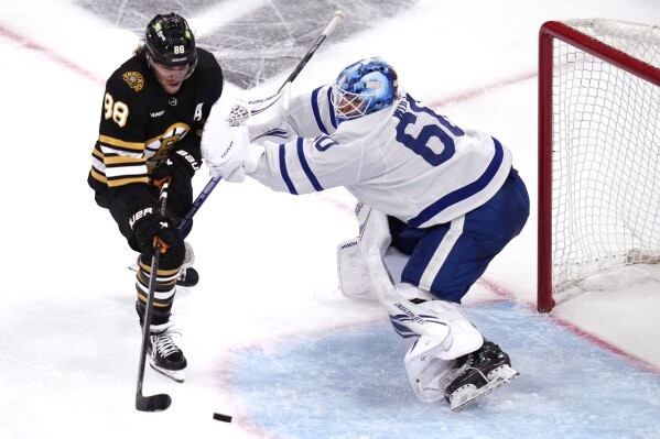 Toronto Maple Leafs goaltender Joseph Woll (60) checks Boston Bruins right wing David Pastrnak (88) on a shot during the third period of Game 5 of an NHL hockey Stanley Cup first-round playoff series, Tuesday, April 30, 2024, in Boston. (AP Photo/Charles Krupa)