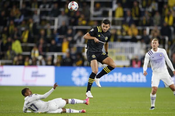 Columbus Crew's Miguel Berry, center, kicks the ball over Orlando City's Nani during the first half of an MLS soccer match Wednesday, Oct. 27, 2021, in Columbus, Ohio. (AP Photo/Jay LaPrete)
