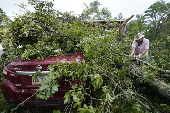 FILE - Span McGinty uses his chain saw to cut fallen tree limbs from a tornado-damaged vehicle at his brother's house in Yazoo County, Miss., on May 3, 2021. 90% of counties in the United States experienced a weather-related disaster between 2011-2021, according to a report published on Wednesday, Nov. 16, 2022. Over 300 million people — 93% of the country’s population — live in those counties. (AP Photo/Rogelio V. Solis, File)