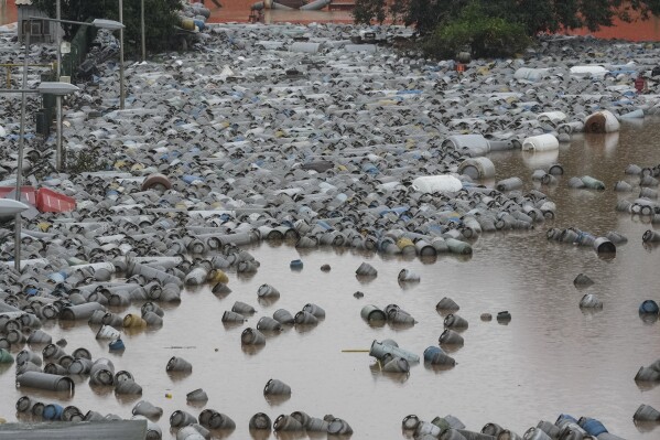 Cilindros de gás flutuam nas águas da enchente em um centro de distribuição de gás após fortes chuvas na província do Rio Grande do Sul, Brasil, sexta-feira, 10 de maio de 2024.  (Foto AP/André Benner)