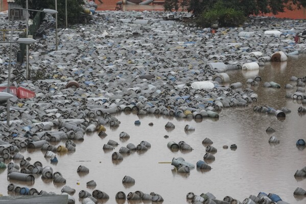 Cilindros de gás flutuam nas águas da enchente em um centro de distribuição de gás após fortes chuvas em Canoas, Rio Grande do Sul, Brasil, sexta-feira, 10 de maio de 2024. (AP Photo/Andre Penner)