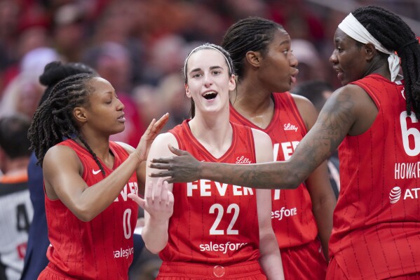 Indiana Fever guard Caitlin Clark (22) is ushered back to the bench area by teammates after being called for a flagrant foul on Chicago Sky forward Angel Reese during the second half an WNBA basketball game in Indianapolis, Saturday, May 17, 2025. (AP Photo/AJ Mast)