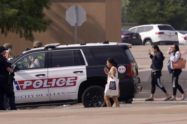 FILE - People raise their hands as they leave a shopping center after a shooting May 6, 2023, in Allen, Texas. Police released video footage Wednesday, June 28, of an officer killing a neo-Nazi gunman, quickly ending a mass shooting that left eight people dead and seven others wounded at the mall. The edited five-and-a-half-minute video details the final moments of Mauricio Garcia, 33, after he unleashed a rain of bullets from an AR-15-style rifle. (AP Photo/LM Otero, File)