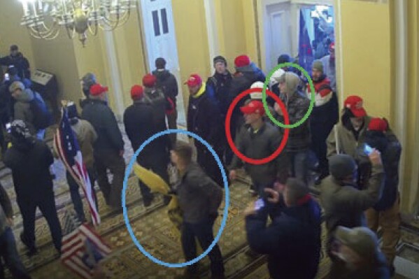 FILE - In this image from U.S. Capitol Police video, released and annotated by the Justice Department in the Statement of Facts supporting an arrest warrant, Joshua Abate, circled in green, Micah Coomer, circled in red, and Dodge Dale Hellonen, circled in blue, appear inside the U.S. Capitol on Jan. 6, 2021, in Washington. Hellonen, one of three active-duty Marines who stormed the U.S. Capitol together, has been sentenced to probation instead of prison time. U.S. District Judge Ana Reyes also on Monday, Sept. 11, 2023, ordered Hellonen to perform 279 hours of community service. (Justice Department via AP, File)