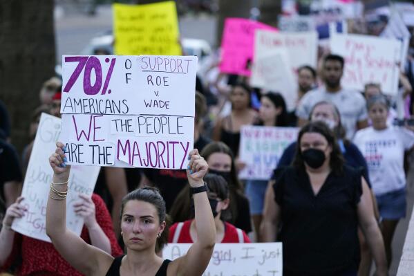 FILE - Protesters march around the Arizona Capitol in Phoenix after the Supreme Court decision to overturn Roe v. Wade, Friday, June 24, 2022. A new Arizona law banning abortions after 15 weeks of pregnancy takes effect Saturday, Sept. 24, 2022 as a judge weighs a request to allow a pre-statehood law that outlaws nearly all abortions to be enforced. (AP Photo/Ross D. Franklin, File)