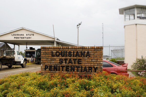 FILE - Vehicles enter the main security gate at the Louisiana State Penitentiary — Angola Prison, the largest high-security prison in the country in Angola, La., Aug. 5, 2008. In a federal court filing dated Monday, July 17, 2023, advocates said that juveniles held in a former death row building at the Louisiana prison for adults are suffering through dangerous heat and psychologically damaging isolation in their cells with little or no mental health care, inadequate schooling and foul water. In the filing, advocates asked a judge to order that the youths be moved. (AP Photo/Judi Bottoni, File)