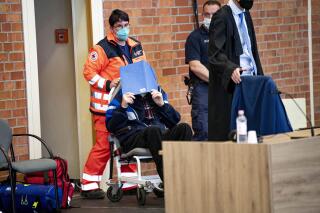 File---File photo shows the defendant coming to the continuation of the trial of the Neuruppin Regional Court, May 16, 2022. According to the indictment, the former concentration camp guard, who is now 101 years old, knowingly and willingly assisted in the murder of camp inmates in 3518 cases between 1942 and 1945 at the Sachsenhausen concentration camp near Berlin. Photo (Fabian Sommer/dpa via AP)