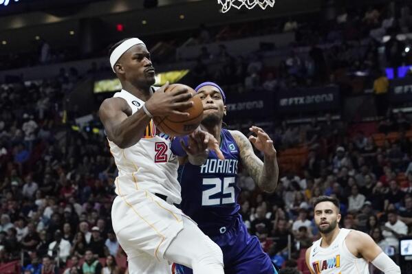 Miami Heat forward Jimmy Butler (22) grabs a rebound from Charlotte Hornets forward P.J. Washington (25) during the first half of an NBA basketball game Thursday, Nov. 10, 2022, in Miami. (AP Photo/Marta Lavandier)