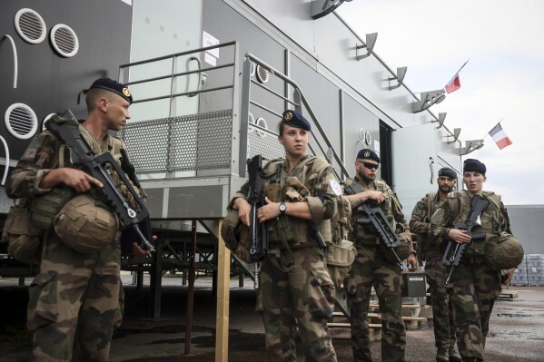 Soldiers leave for a patrol at the military camp set up in the Vincennes woods, Monday, July 15, 2024 just outside Paris. The military camp, with prefabricated barracks and sleeping stretchers, is being built in the east of Paris to house 4,500 soldiers assigned to security during the Paris 2024 Olympic Games. (AP Photo/Thomas Padilla)