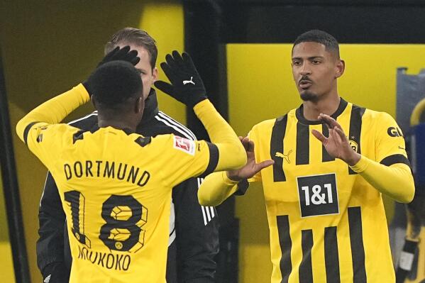 Dortmund's Sebastien Haller, right, high fives with Dortmund's Youssoufa Moukoko when entering the pitch as substitute player during the German Bundesliga soccer match between Borussia Dortmund and FC Augsburg in Dortmund, Germany, Sunday, Jan. 22, 2023. (AP Photo/Martin Meissner)