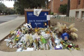 A memorial for University of Arizona professor Thomas Meixner is seen outside the school's Department of Hydrology and Atmospheric Sciences building in Tucson, Ariz., on Friday, Oct. 14, 2022. Authorities say Murad Dervish, a former graduate student accused of fatally shooting the professor on campus earlier this month, has been indicted on seven felony charges including first-degree murder. (AP Photo/Terry Tang)